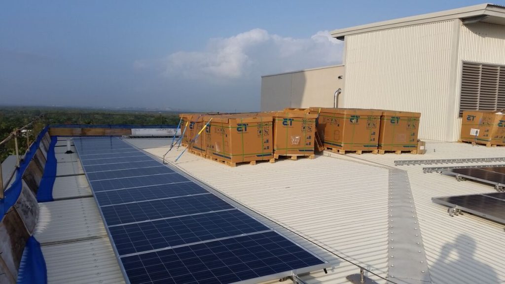 Rooftop solar install underway with pallets of panels and equipment