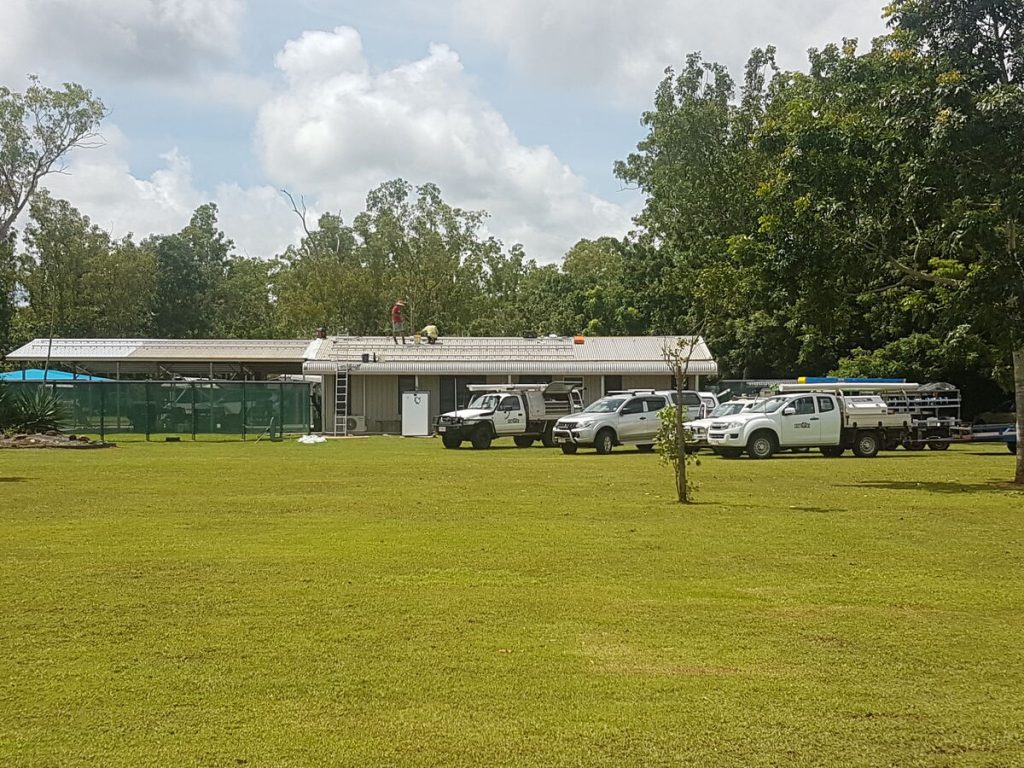 Work utes and crew at a rural solar installation